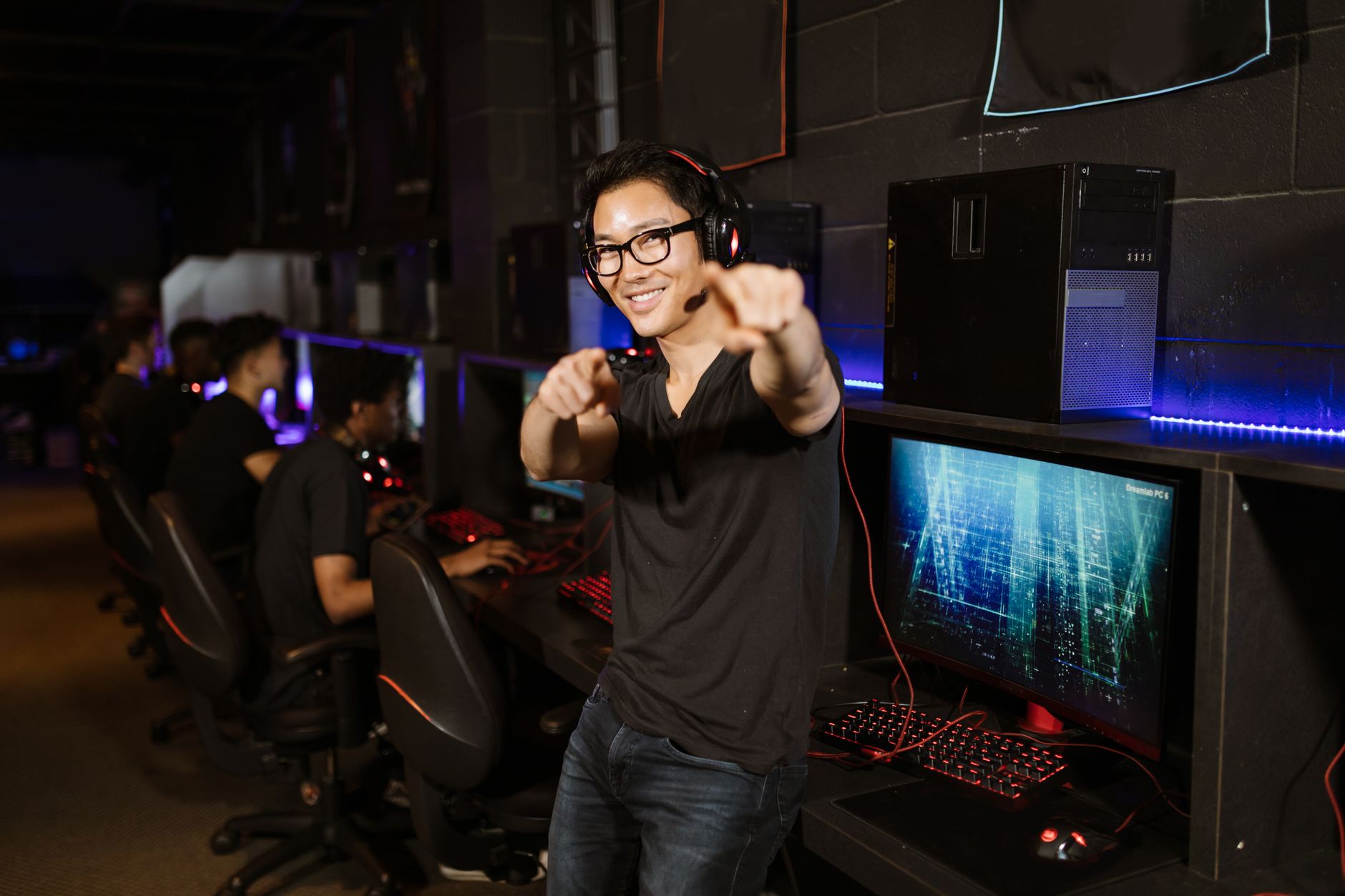 Confident gamer enjoying recreational gaming indoors. Modern technology setting with gaming computers.