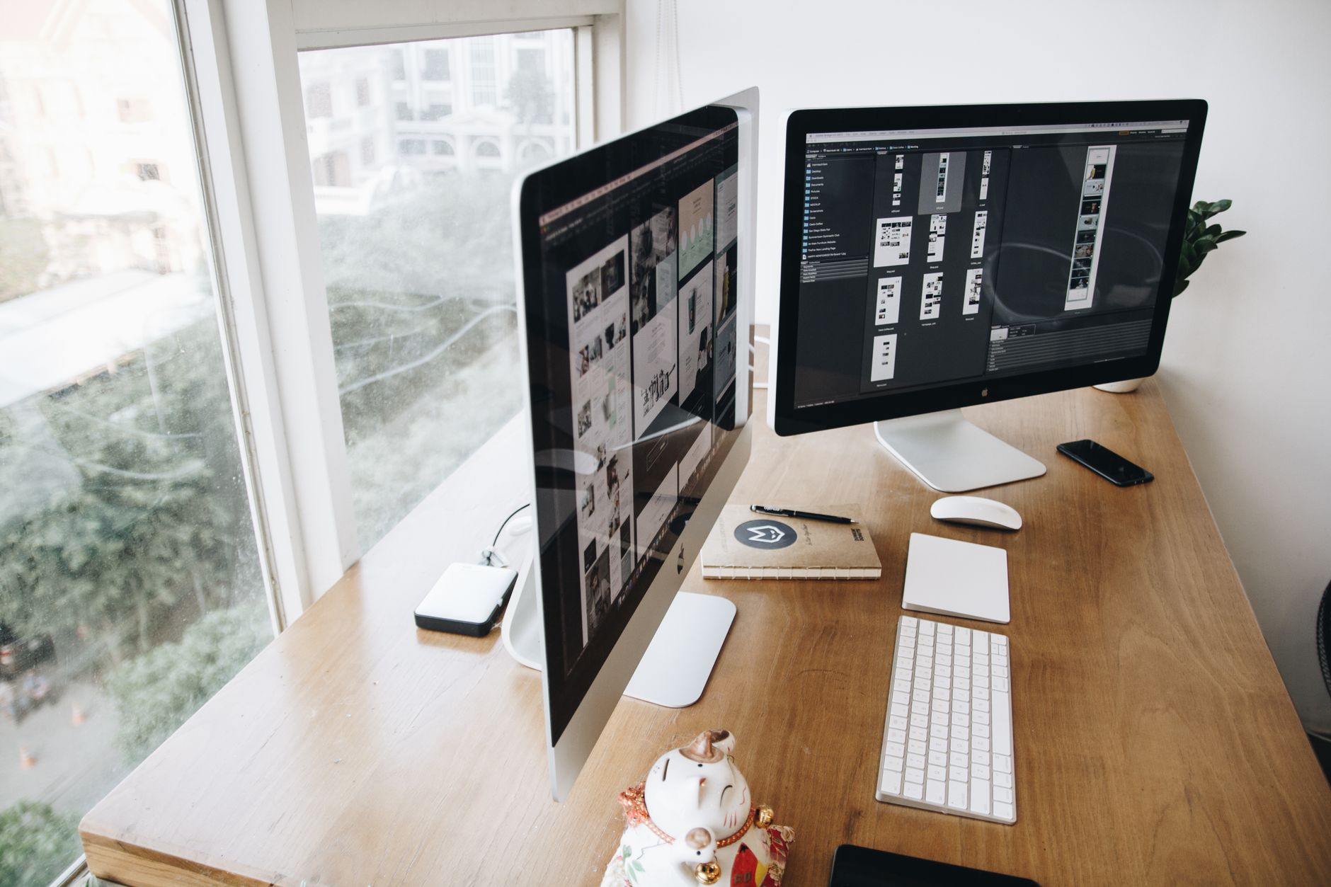 A well-organized modern office desk with dual computer screens and various devices.