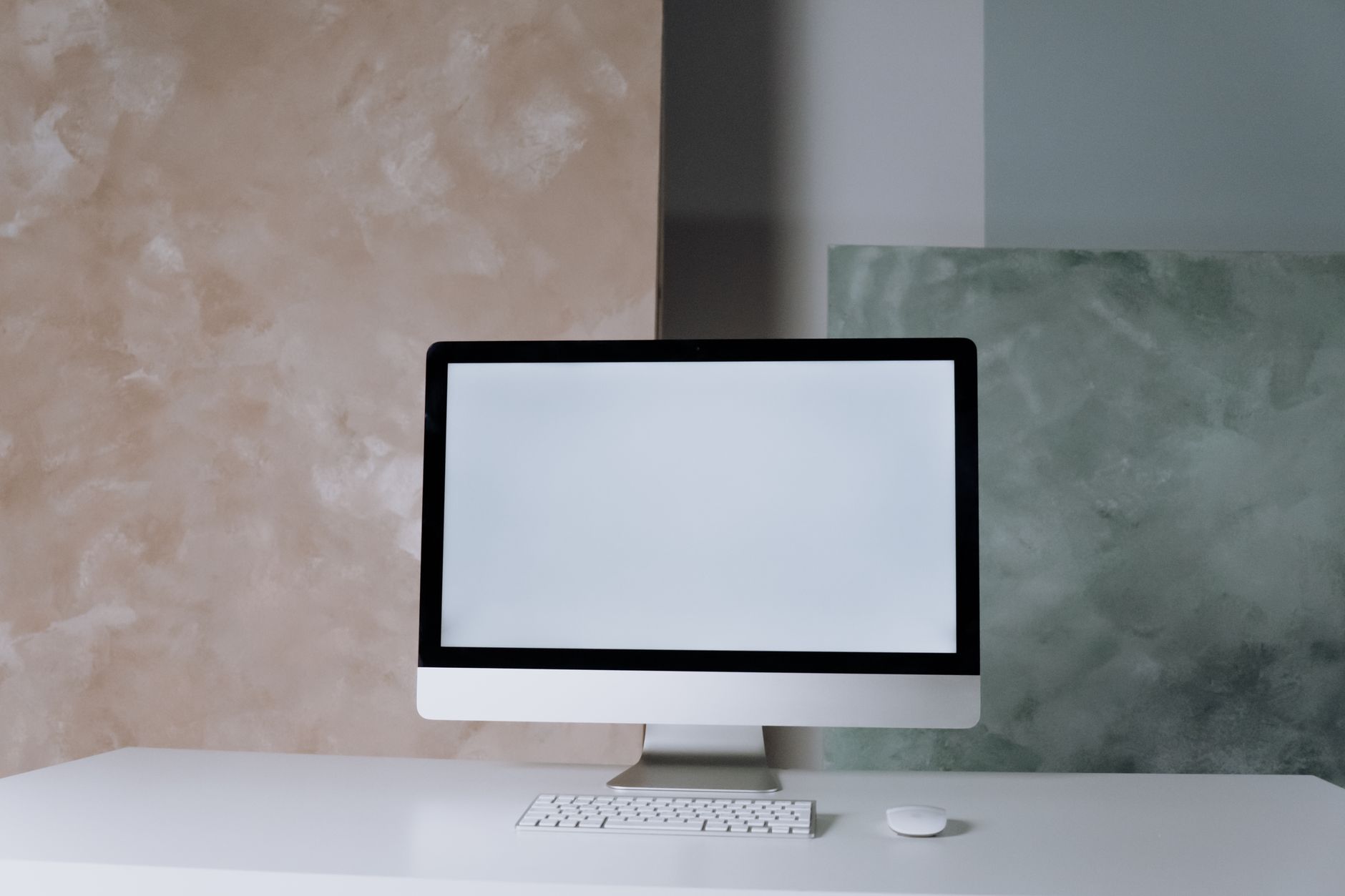 Elegant desktop setup featuring a computer screen, keyboard, and mouse against a modern abstract background.