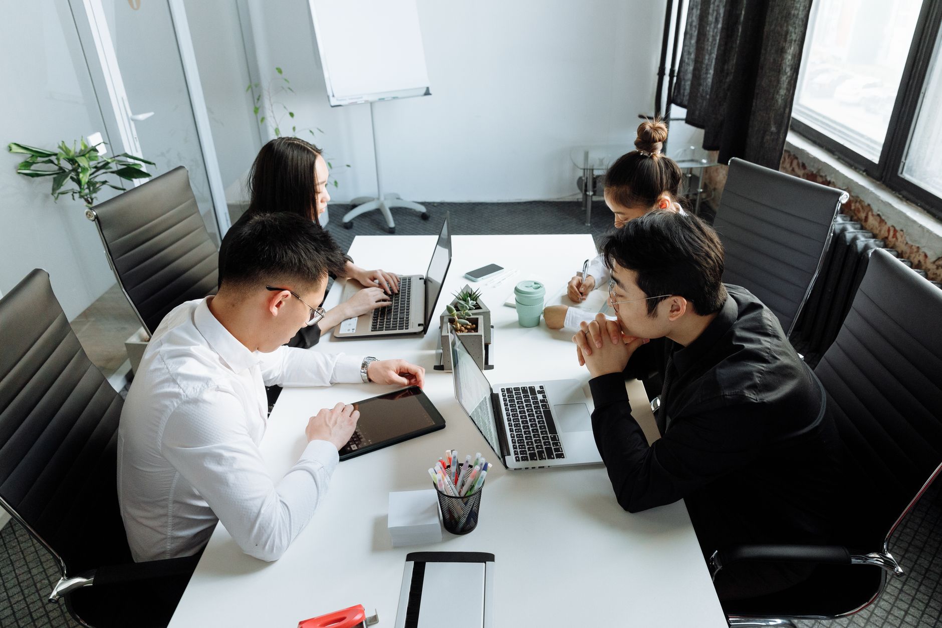 Team of young professionals engaged in collaborative work at a modern office setting.