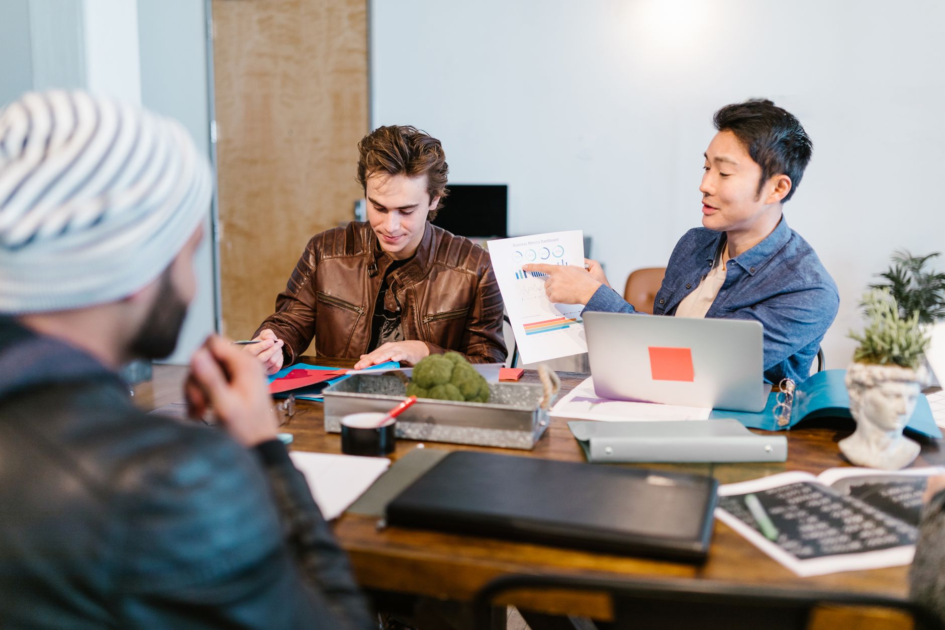Team discussing project ideas in a modern office, focusing on documents and collaboration.
