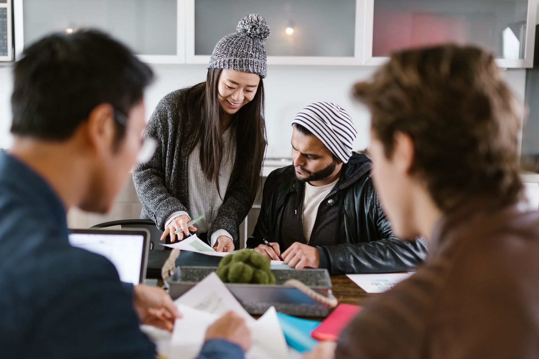 A multicultural team of adults collaborating on a project, highlighting diversity and teamwork.