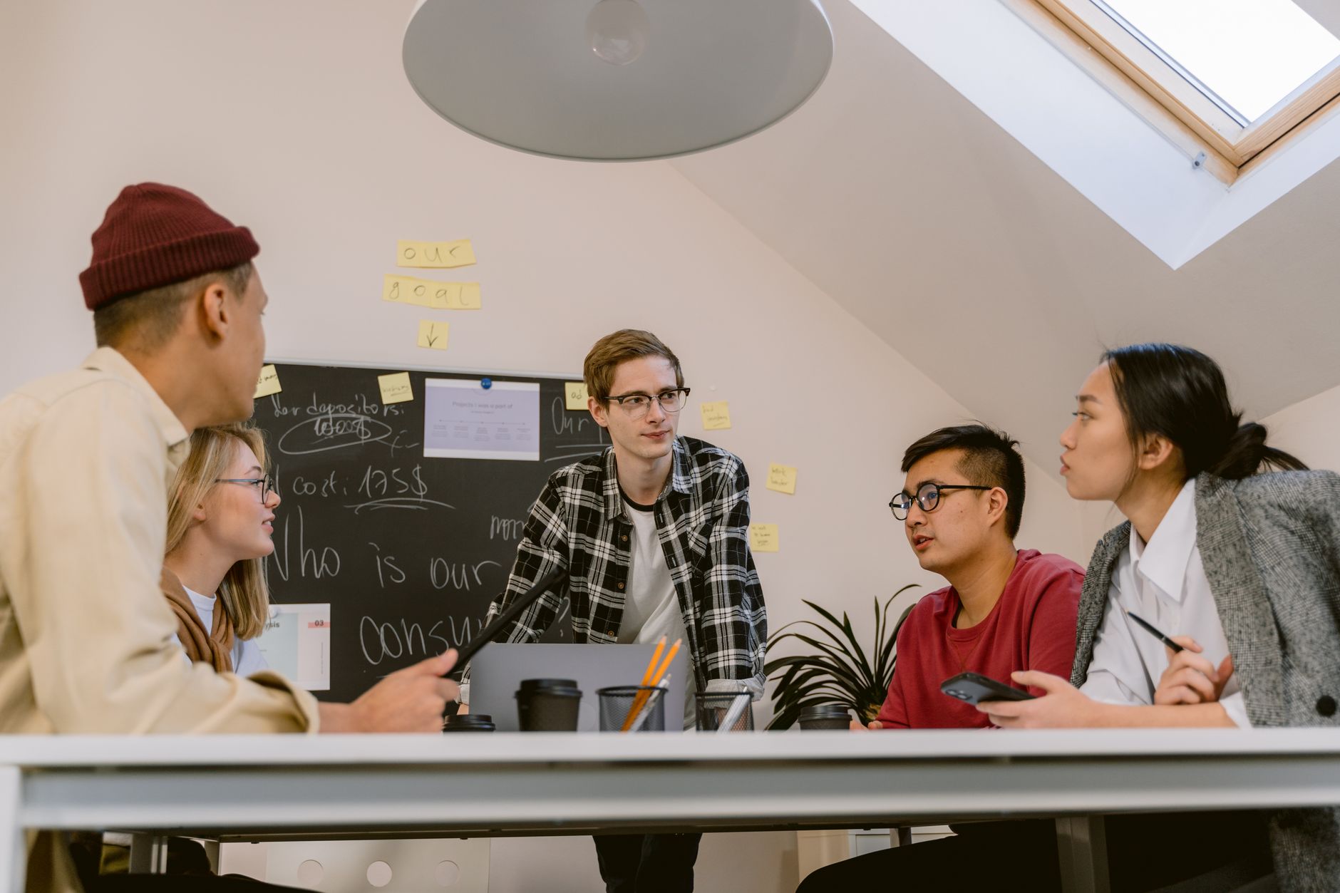 A diverse group of adults collaborating on a project in an office with a focus on creative brainstorming.