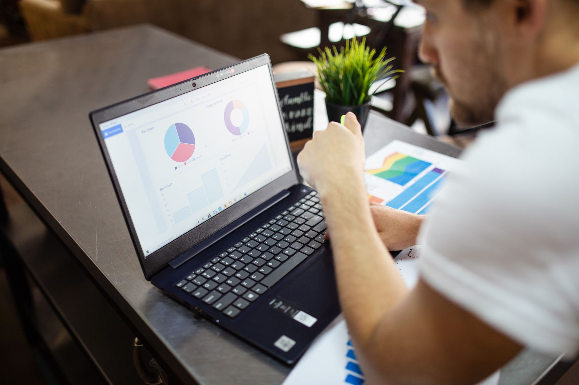 Man reviewing charts and graphs on a laptop for business analysis.