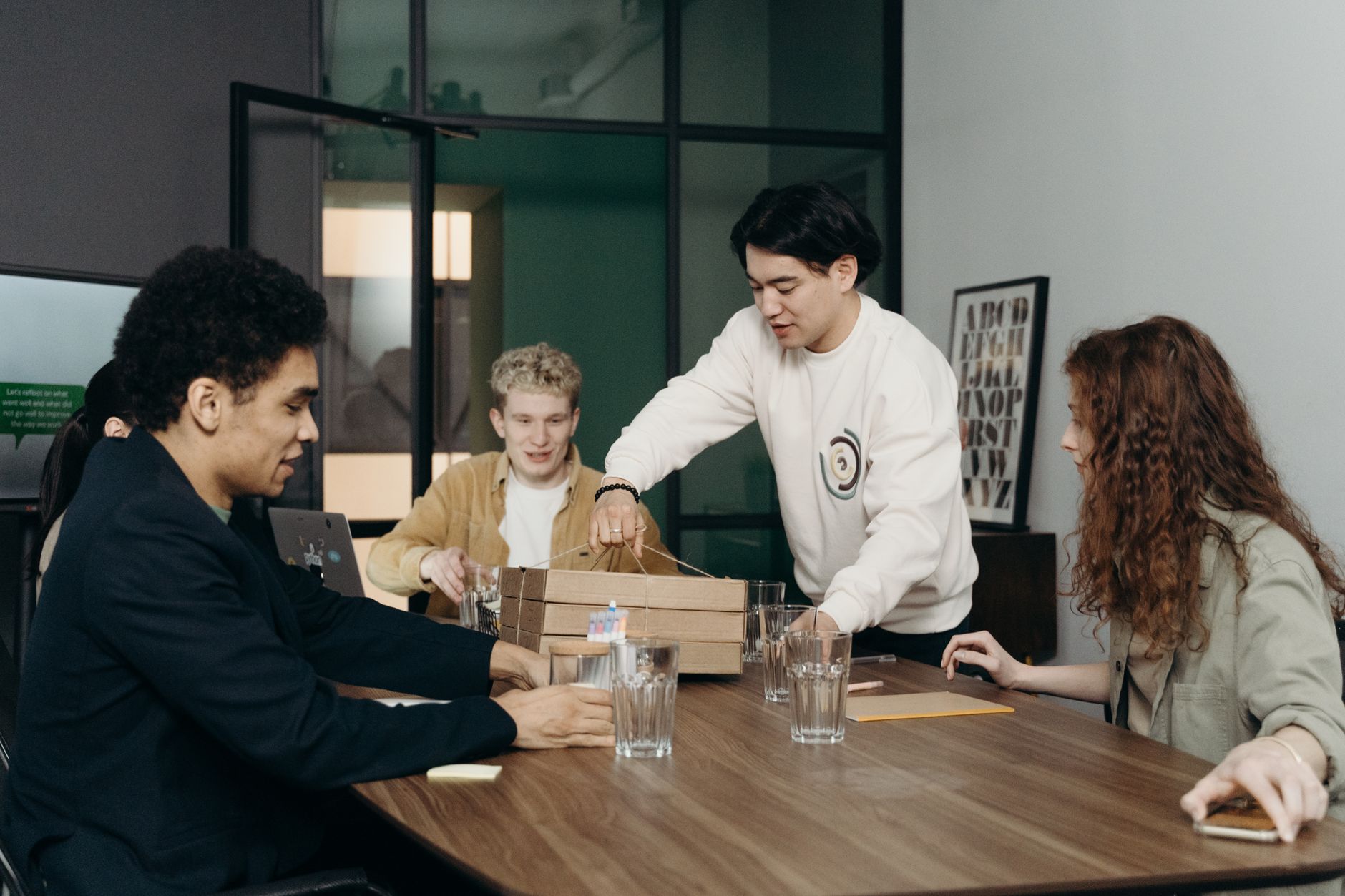 A diverse group of young professionals enjoying a lunch break together in a modern office setting.