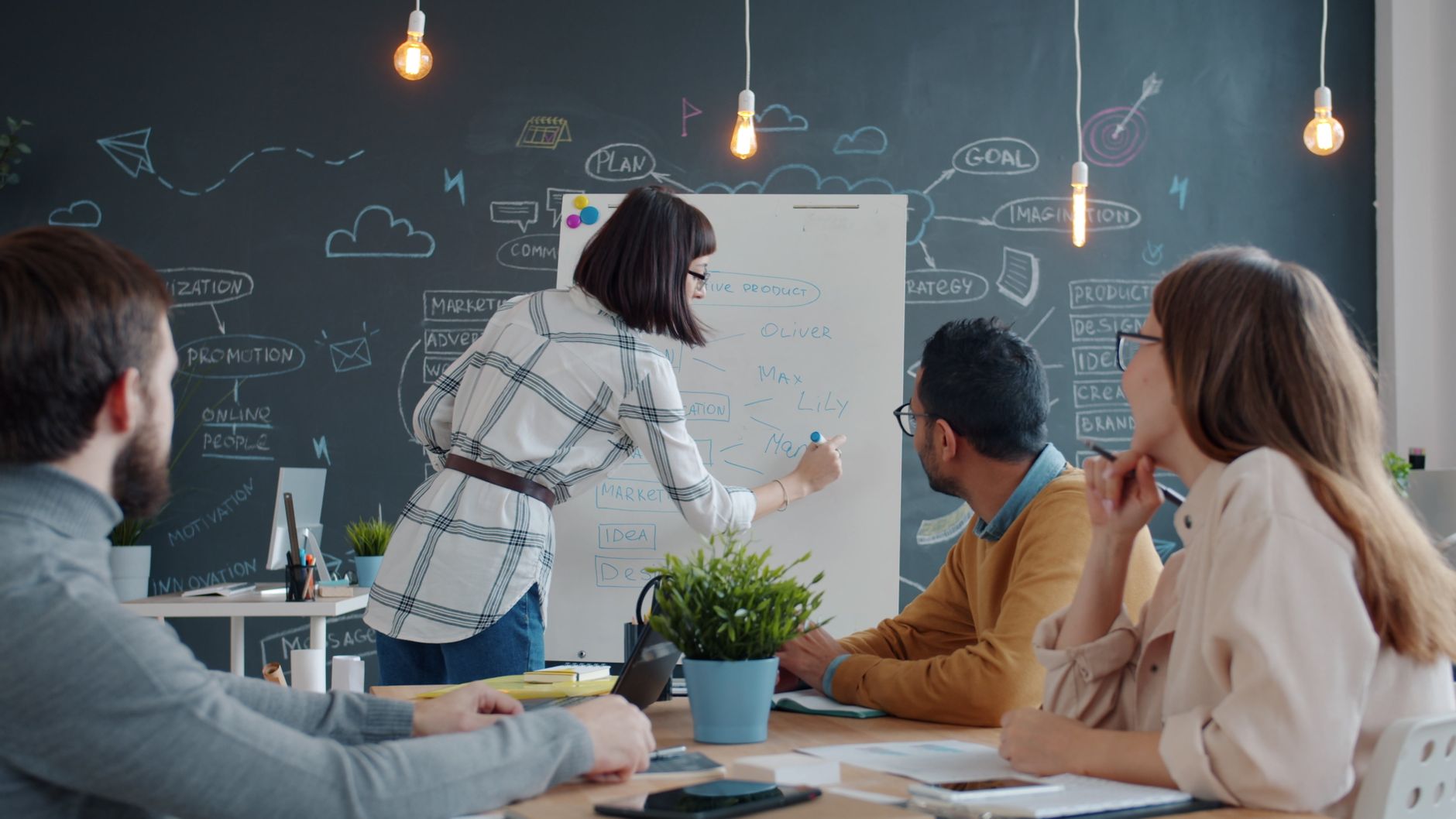 Group of colleagues collaborating on a project in a creative meeting room.