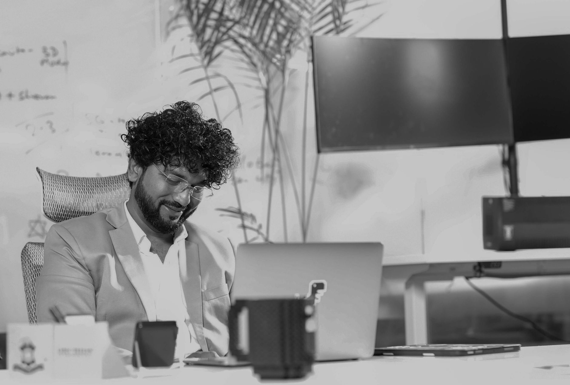 A business professional working on a laptop at a modern office desk.
