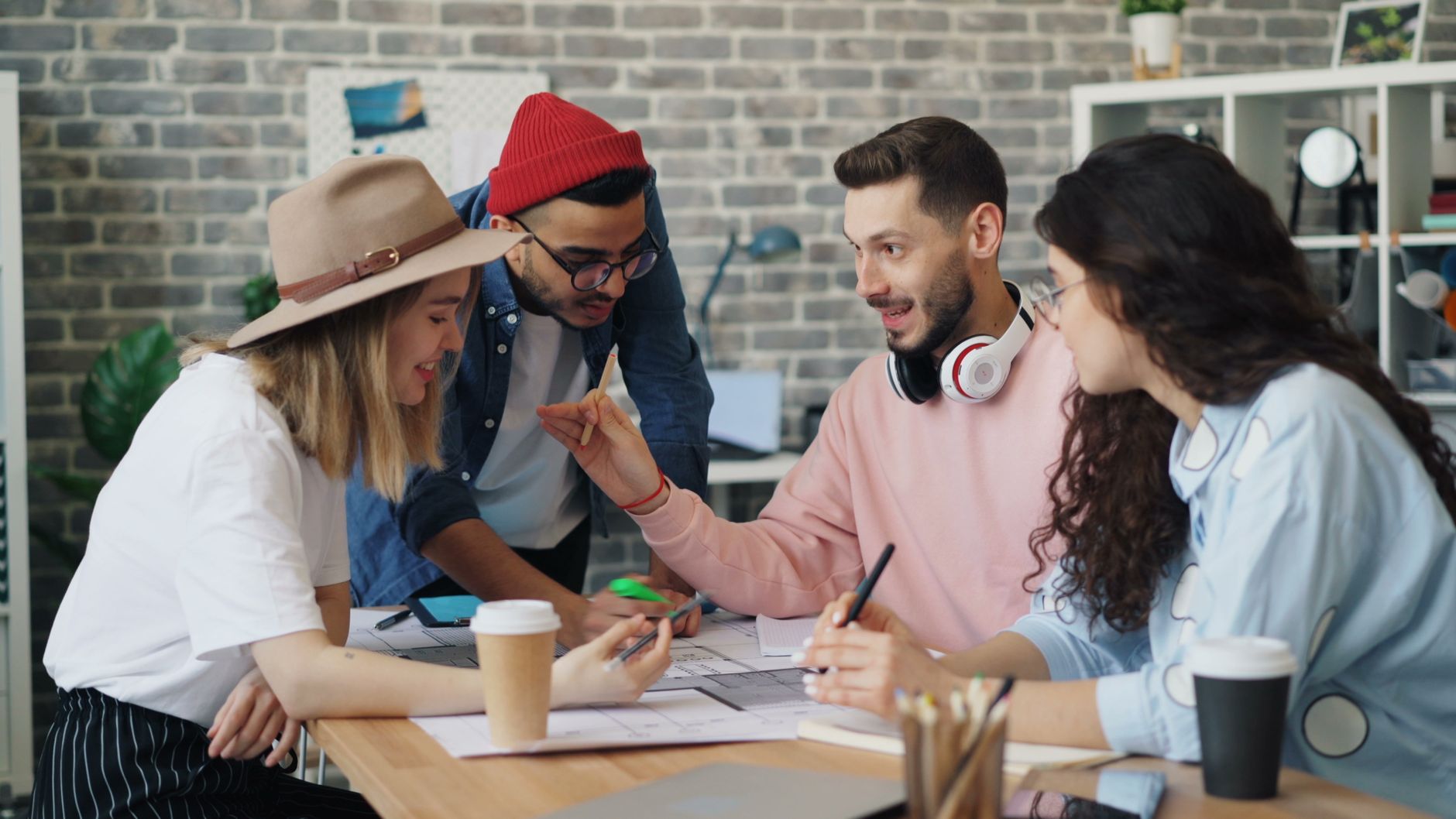Young diverse team brainstorming together in a modern office setting, promoting teamwork and innovation.