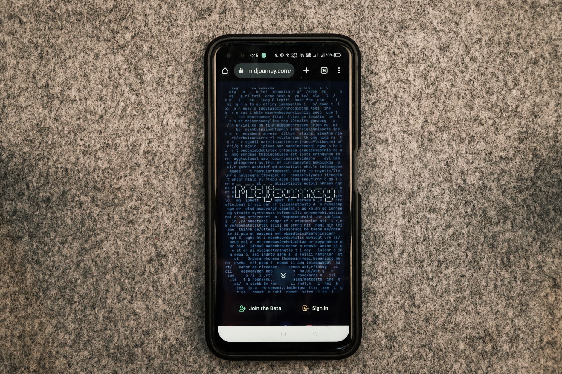 A smartphone showing the Midjourney website on its screen against a gray textured surface.