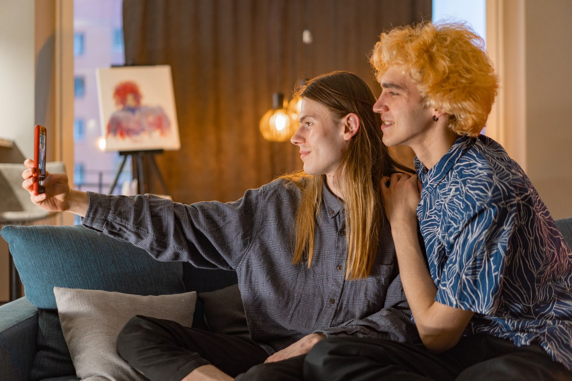 A young couple enjoying a moment together, taking a selfie in a warm, cozy home setting.