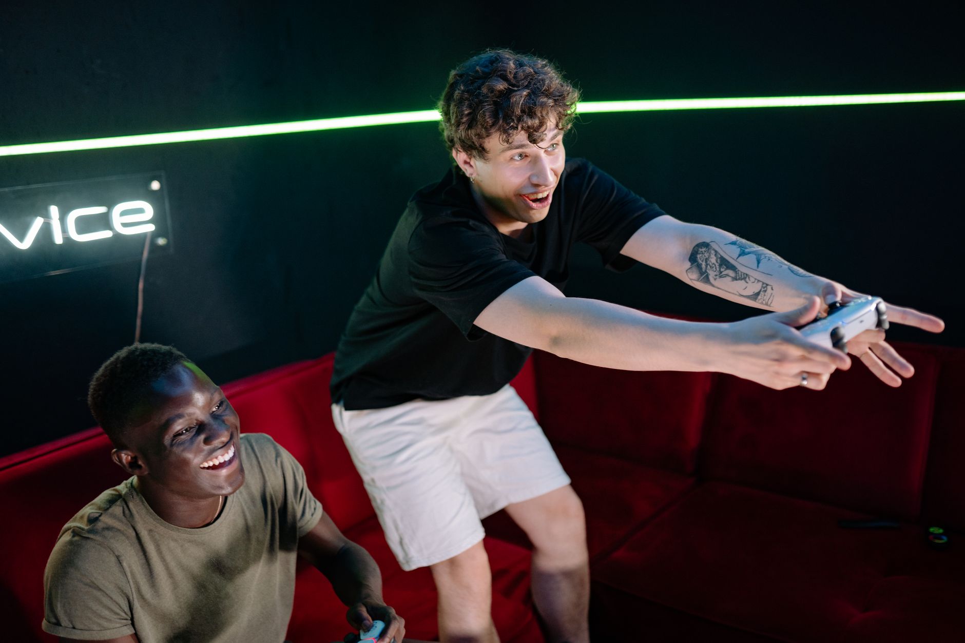 Two young men having fun playing video games in a cozy indoor setting.