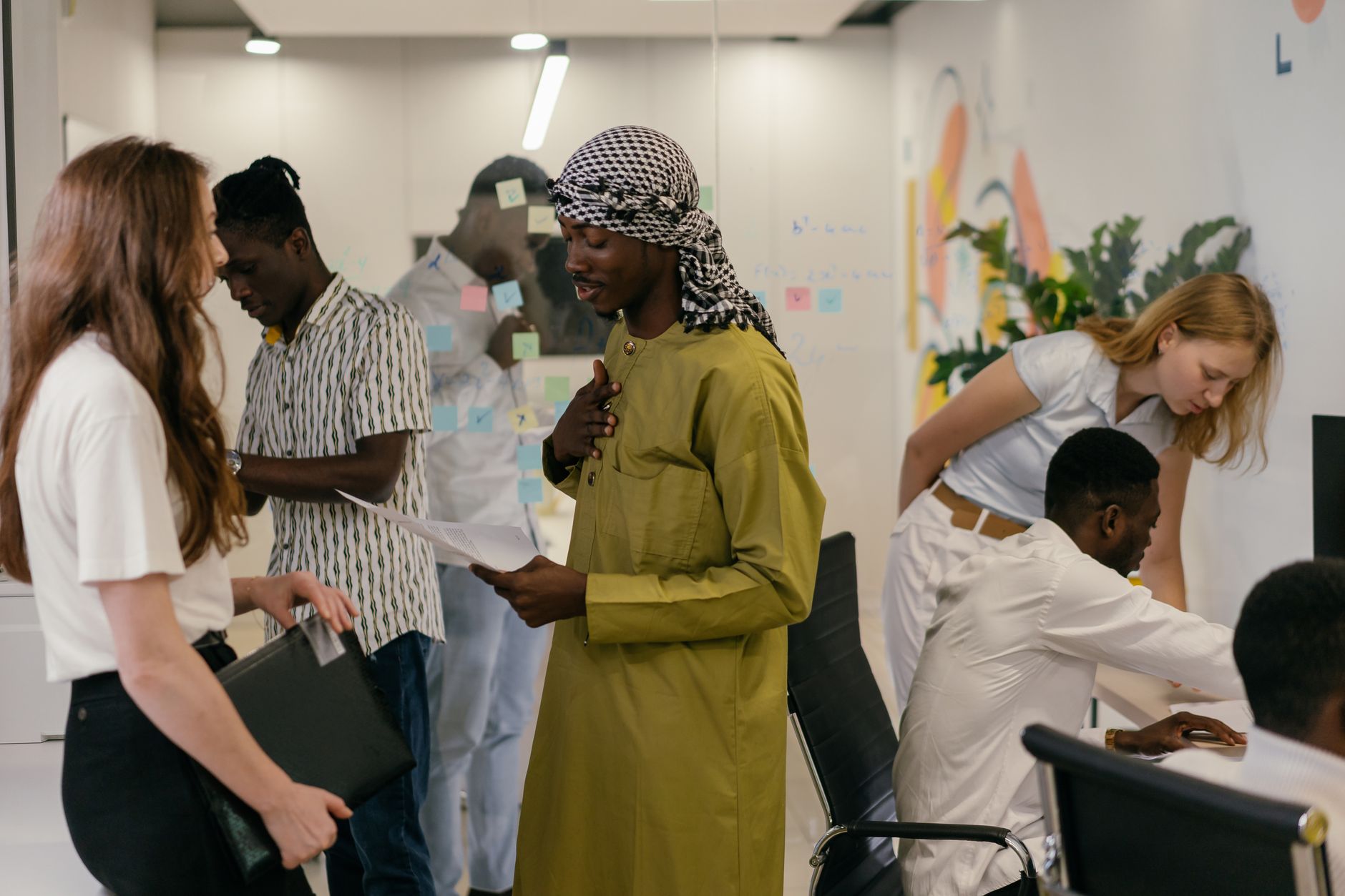 Diverse team engaged in discussion and collaboration in a modern office setting, showcasing teamwork and diversity.